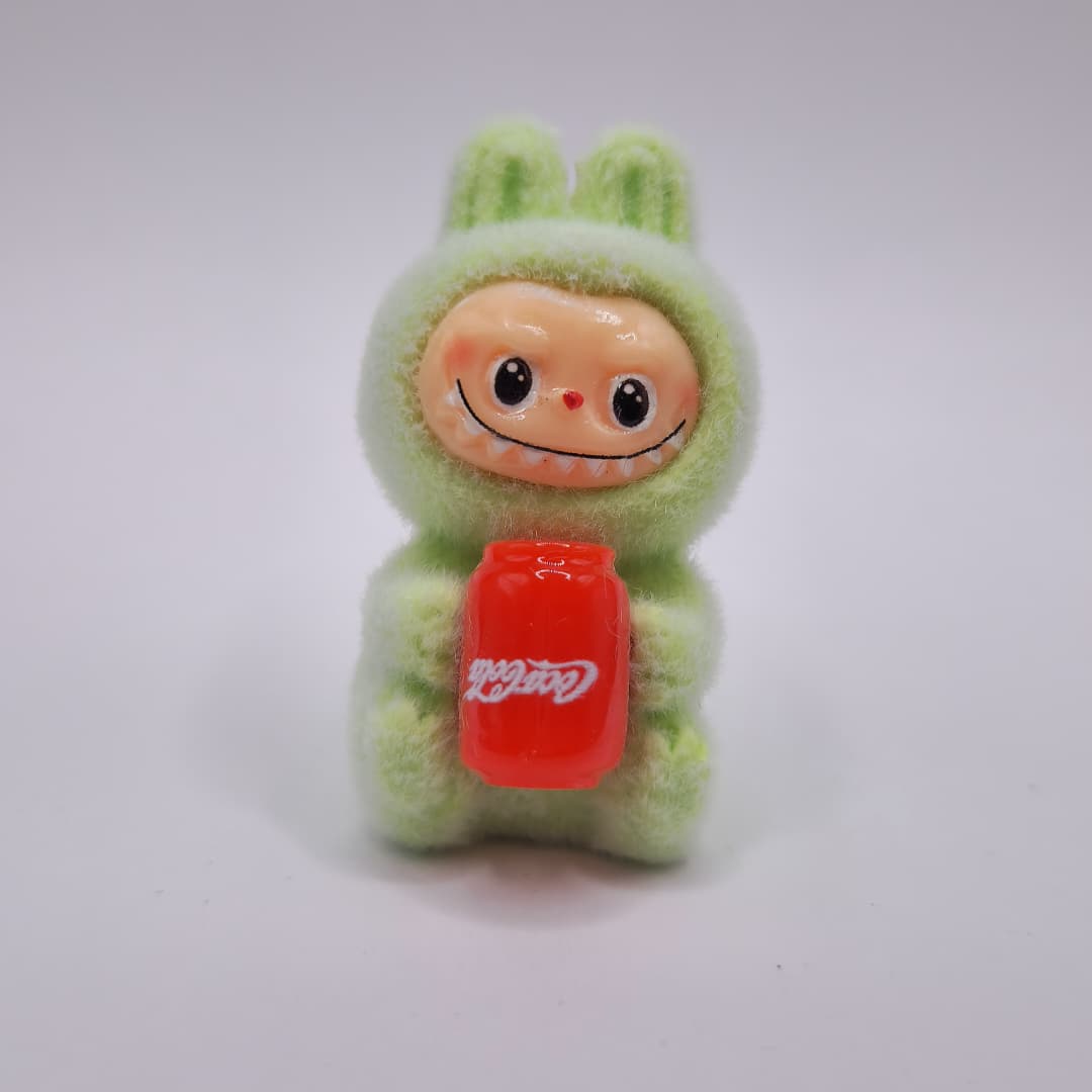 LABUBU VERDE SENTADO CON COCA COLA DE LATA