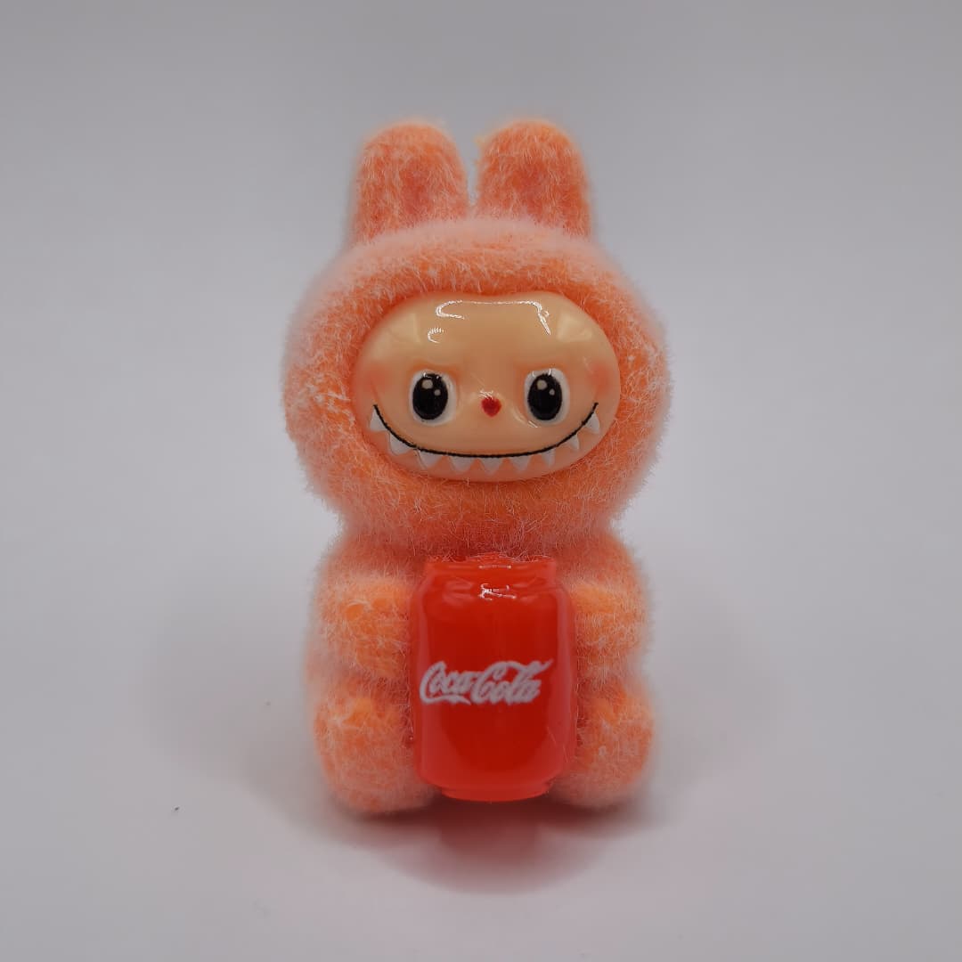 LABUBU NARANJA SENTADO CON COCA COLA DE LATA