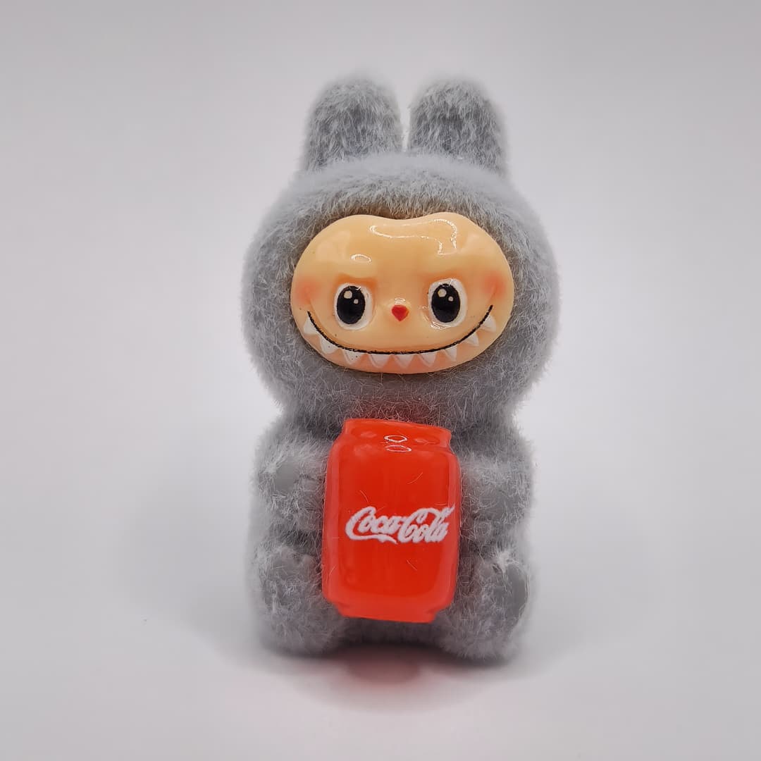 LABUBU GRIS SENTADO CON COCA COLA DE LATA