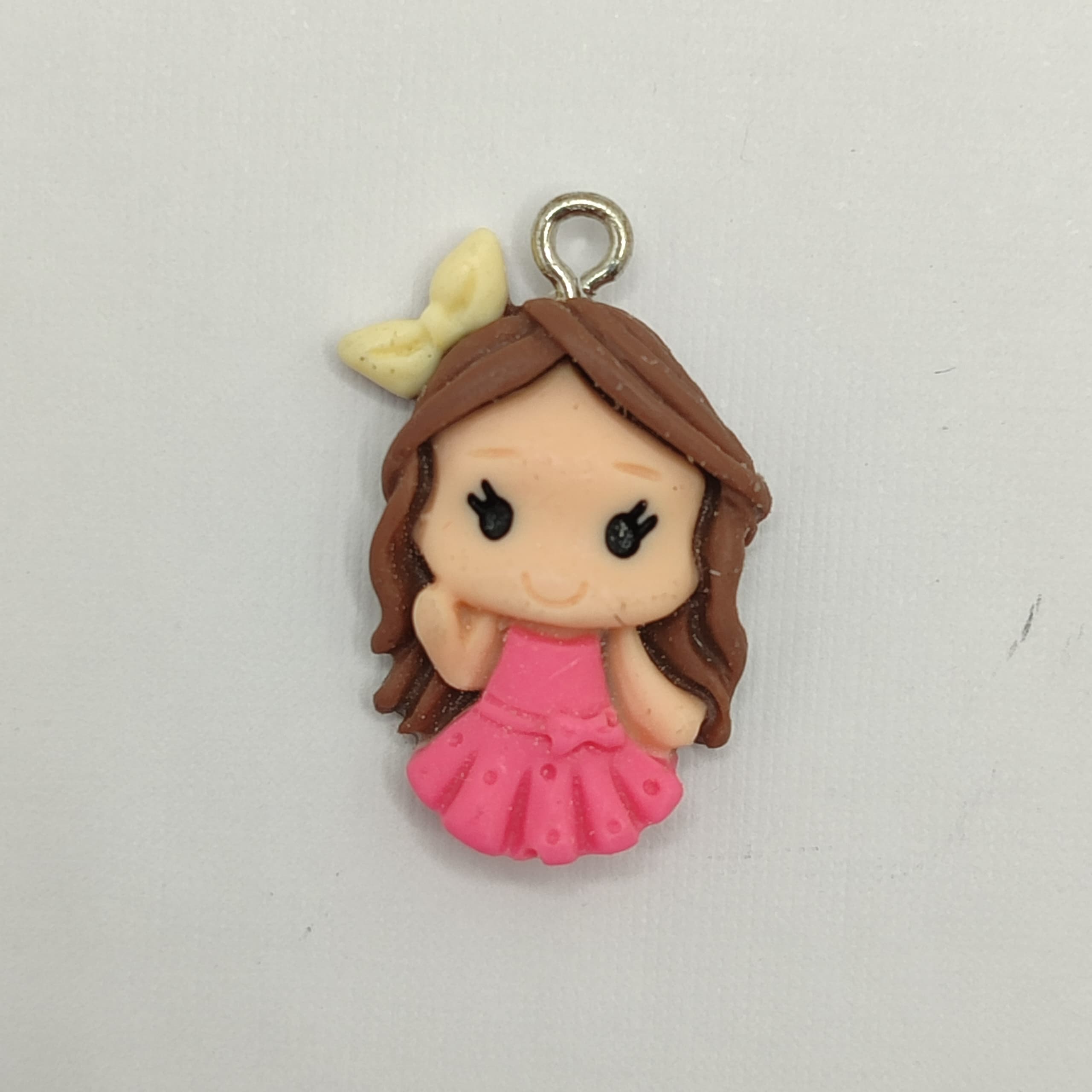 RESINA DIJE NIÑA CON VESTIDO ROSADO Y LAZO